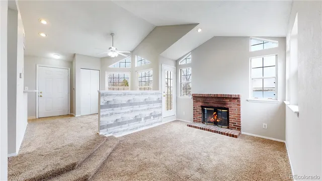 an empty room with windows and fireplace