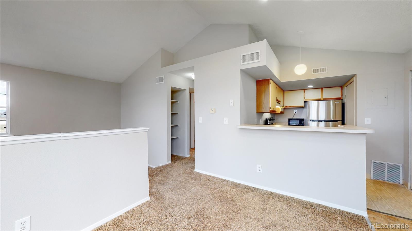 4760 South Wadsworth Boulevard, Unit F208 Littleton, CO 80123 - Photo 7 of 30 a view of a kitchen with a refrigerator a sink and a refrigerator