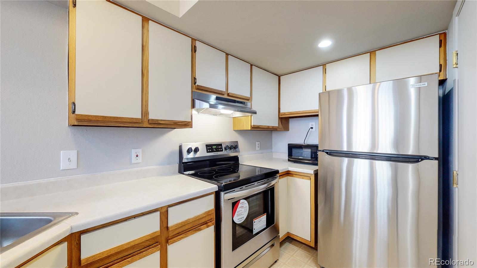 4760 South Wadsworth Boulevard, Unit F208 Littleton, CO 80123 - Photo 10 of 30 a kitchen with stainless steel appliances a refrigerator sink and cabinets