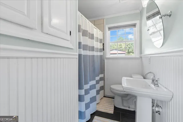 a bathroom with a sink a toilet and a mirror