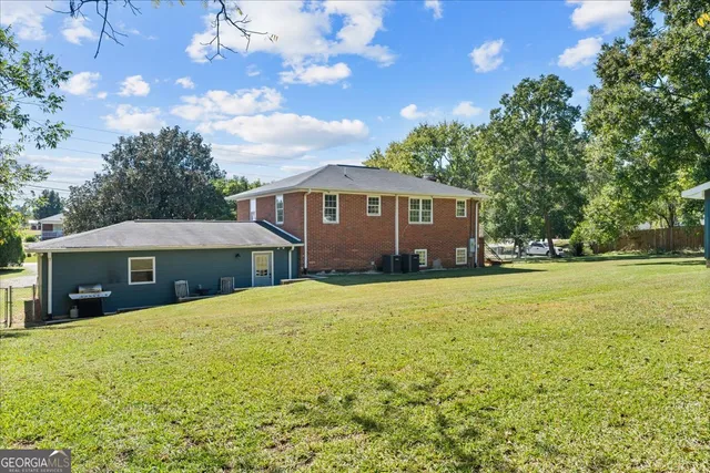a view of a house with backyard and tree