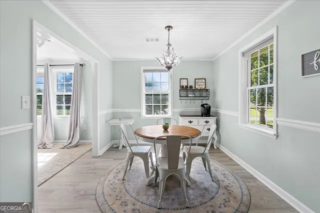a dining room with furniture a chandelier and wooden floor
