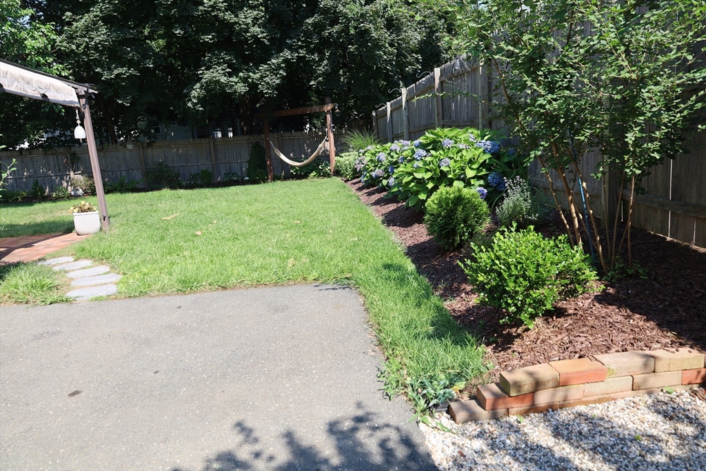 95 Mayflower Road Springfield, MA 01118 - Photo 4 of 20 a view of a backyard with potted plants and large trees