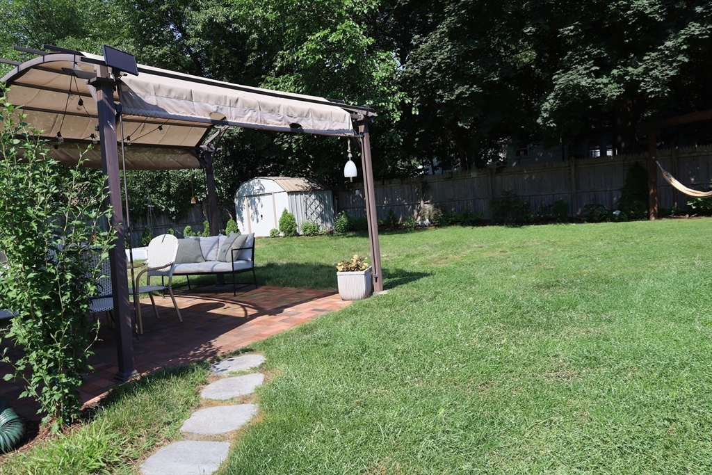 95 Mayflower Road Springfield, MA 01118 - Photo 5 of 20 a view of a patio with table and chairs potted plants and large tree