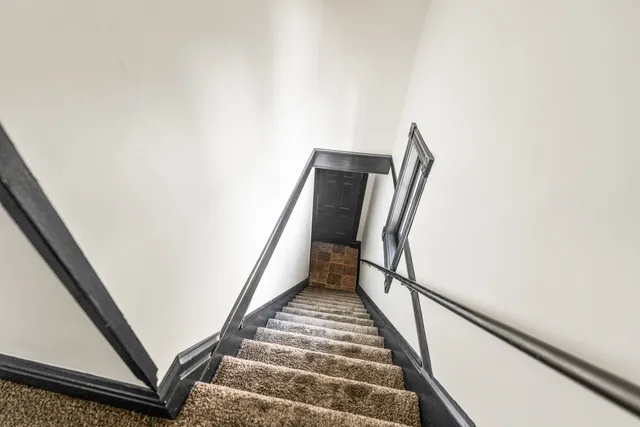 a view of staircase with wooden floor and chair