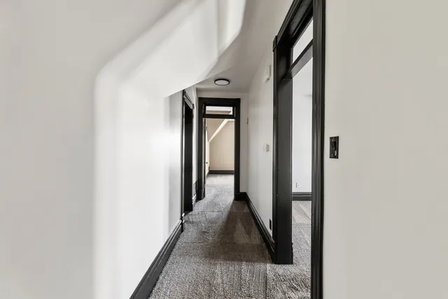 a view of a hallway with wooden floor and staircase