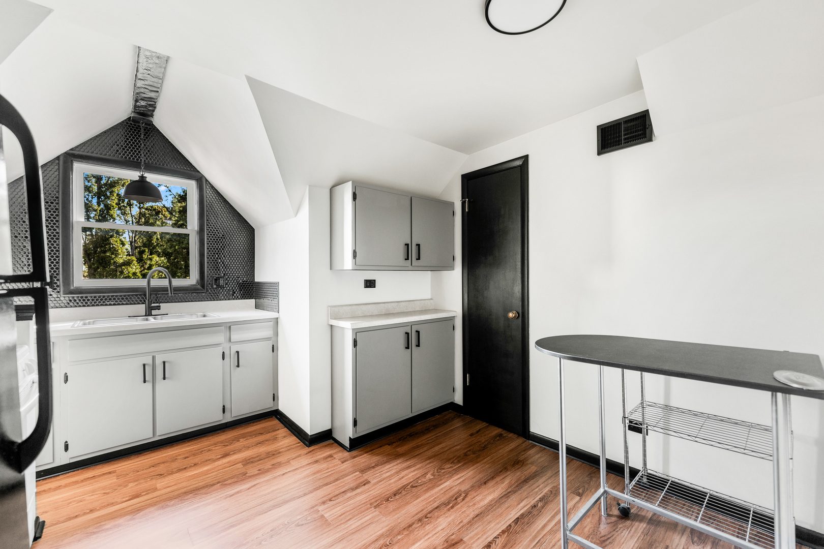 113 Elm Street, Unit C Elgin, IL 60123 - Photo 8 of 14 a view of cabinets with wooden floor and windows