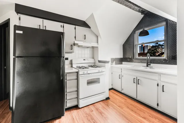 a kitchen with a refrigerator sink and cabinets