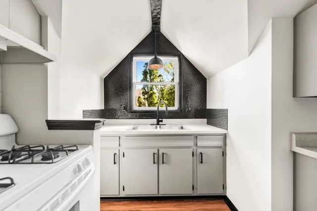a kitchen with a sink stove and cabinets