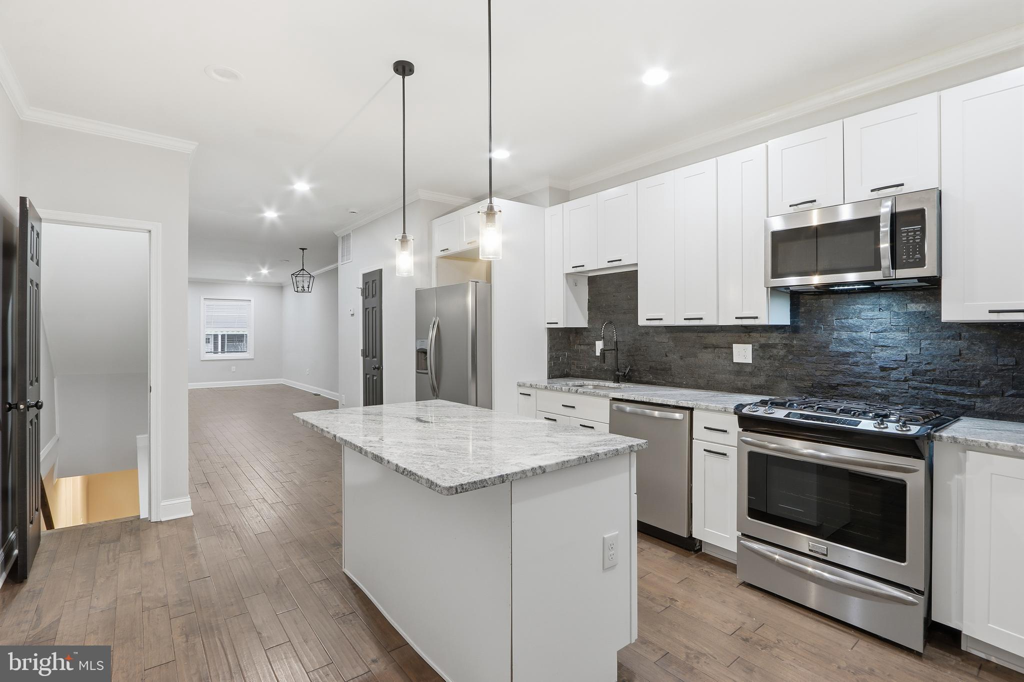 3540 Keswick Road Baltimore, MD 21211 - Photo 10 of 41 a kitchen with stainless steel appliances kitchen island a white cabinets and refrigerator