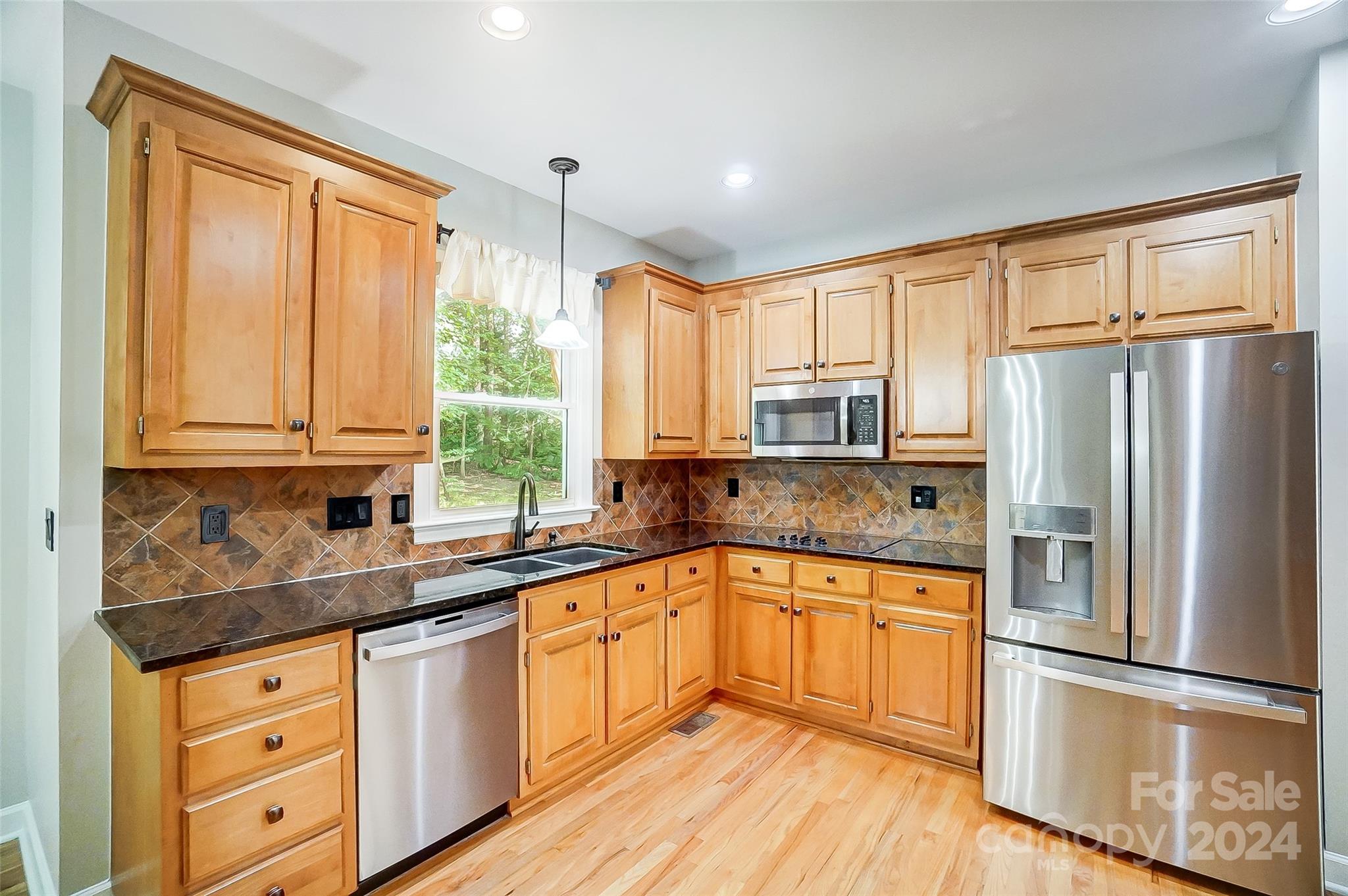15110 MacBeth Court Huntersville, NC 28078 - Photo 4 of 36 a kitchen with granite countertop stainless steel appliances a sink cabinets and a window