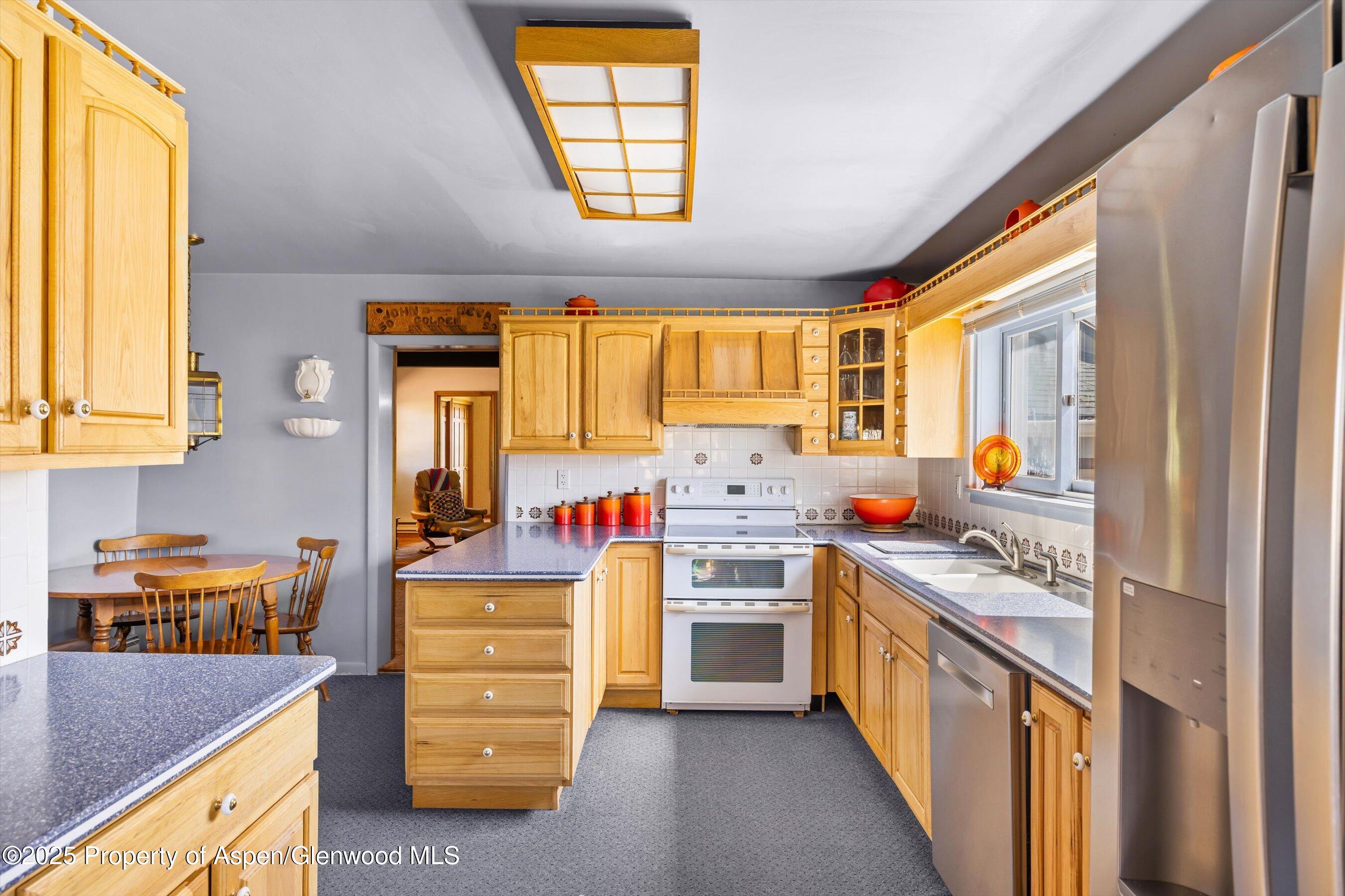 7781 County Road 320 Rifle, CO 81650 - Photo 21 of 63 a kitchen with stainless steel appliances granite countertop a stove and a refrigerator
