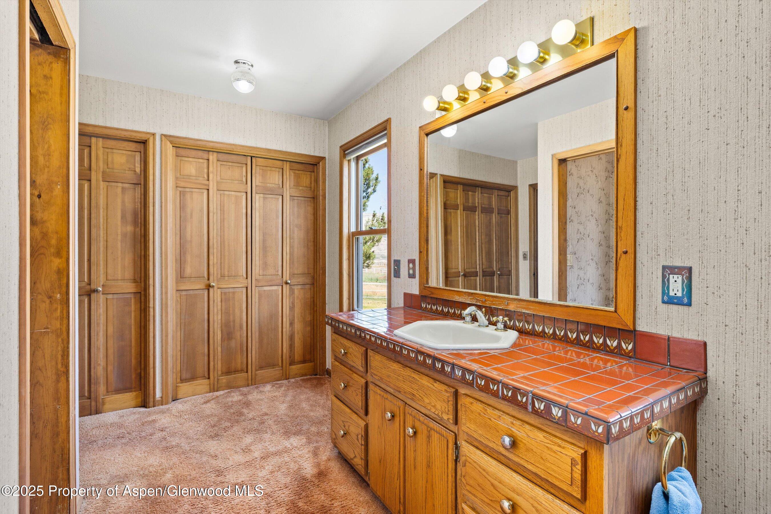 7781 County Road 320 Rifle, CO 81650 - Photo 35 of 63 a spacious bathroom with a double vanity sink and a mirror