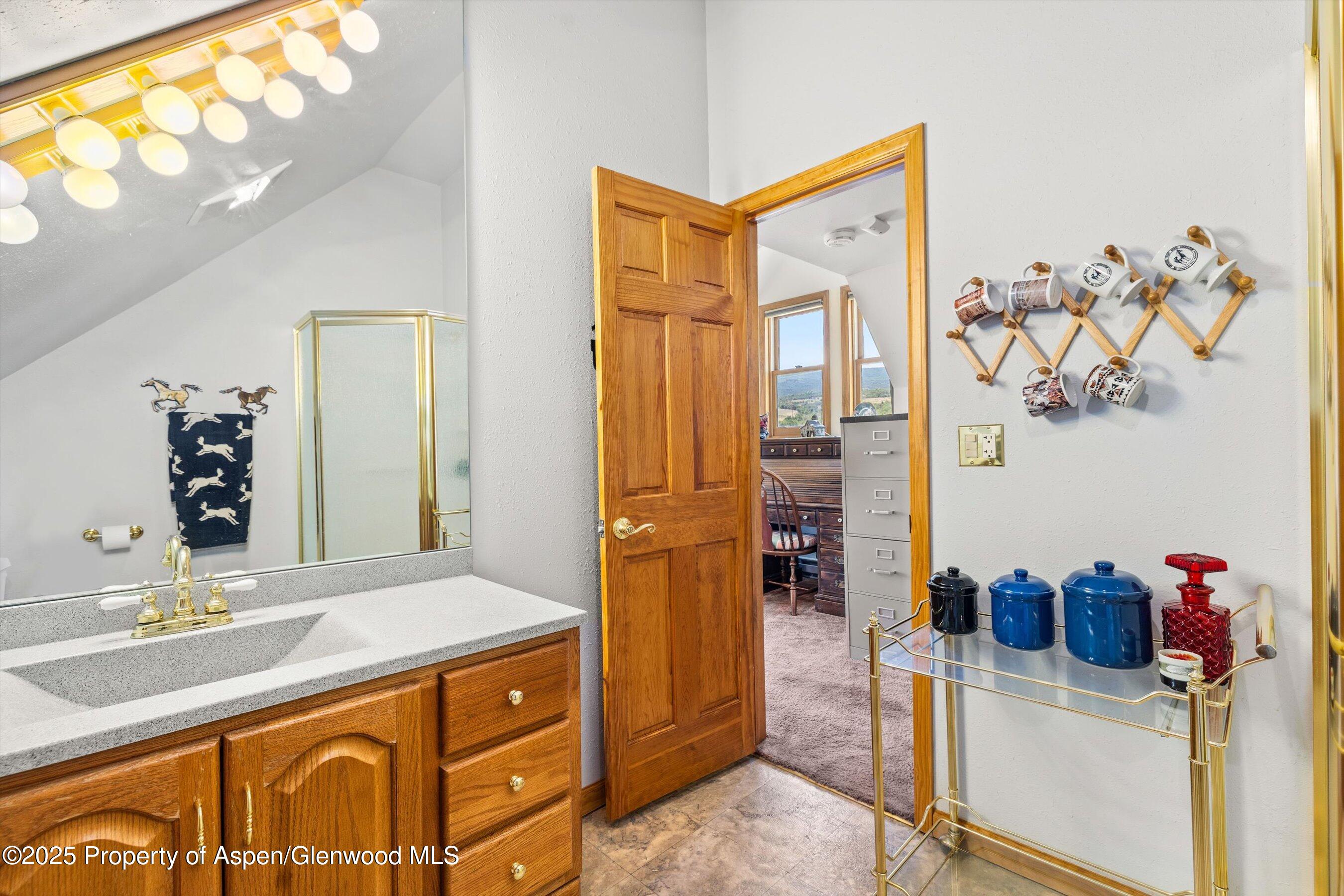 7781 County Road 320 Rifle, CO 81650 - Photo 51 of 63 a bathroom with a granite countertop sink and a mirror