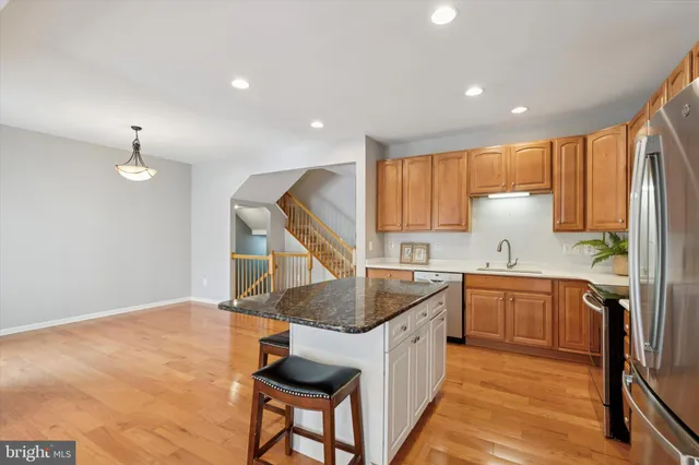 a kitchen with granite countertop a sink a counter space appliances and cabinets