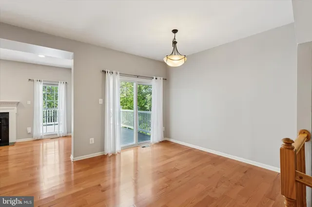 a view of empty room with wooden floor and window