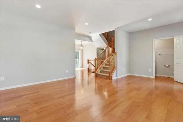 an empty room with wooden floor and staircase