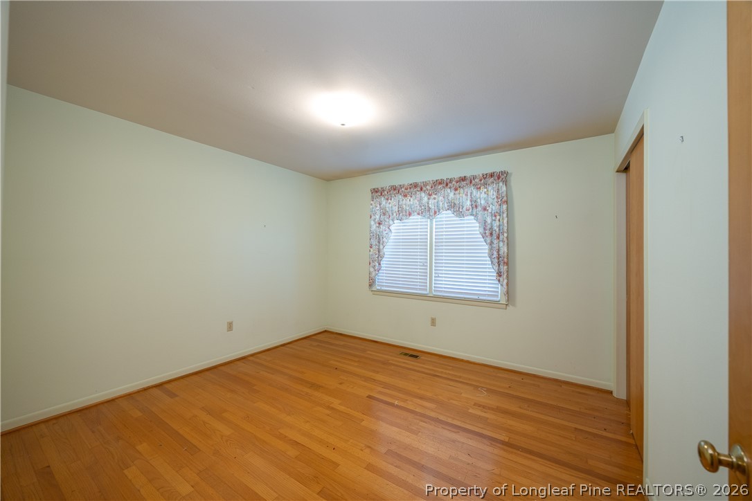 5424 Bonnetsville Road Clinton, NC 28328 - Photo 15 of 29 a view of an empty room with wooden floor and a window