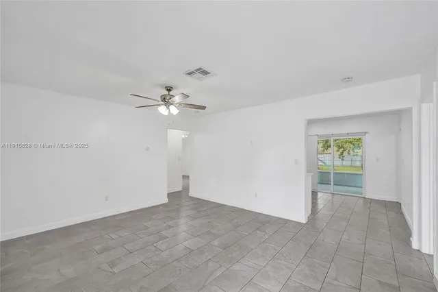 an empty room with a chandelier fan