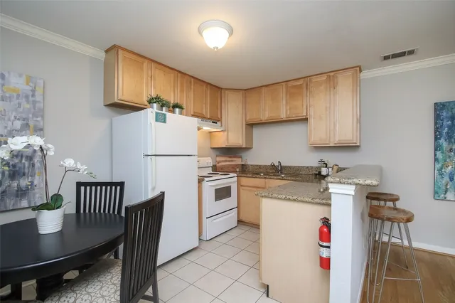 a kitchen with a table chairs refrigerator and cabinets