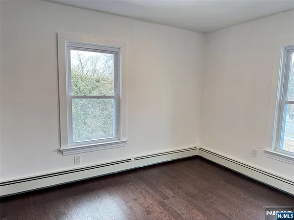 an empty room with wooden floor and window