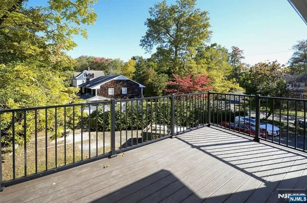 a view of a brick house with wooden floor and fence