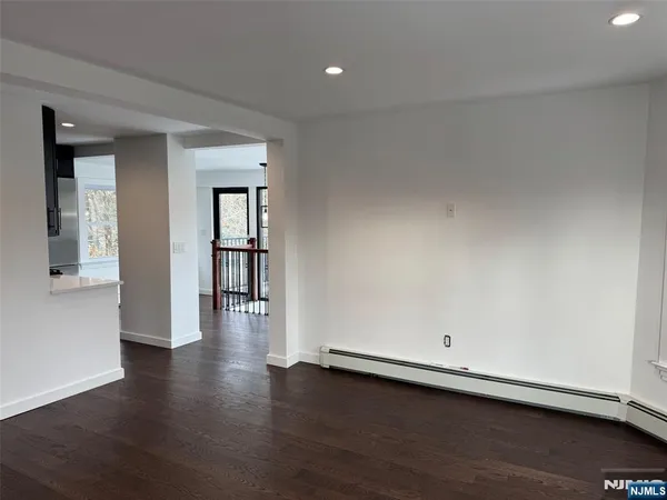 an empty room with wooden floor and pool table