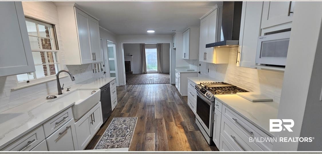 159 Conway Drive West Mobile, AL 36608 - Photo 5 of 24 Kitchen featuring backsplash, white cabinets, and wall chimney exhaust hood