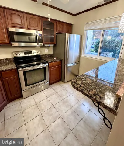 a kitchen with stainless steel appliances granite countertop a refrigerator stove and sink
