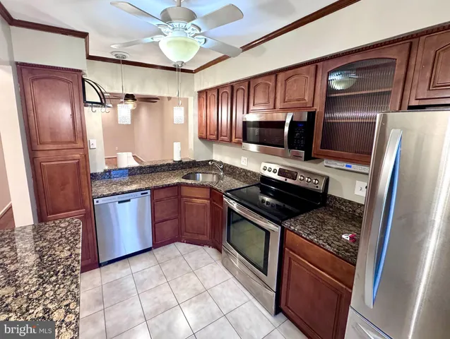 a kitchen with stainless steel appliances granite countertop a stove refrigerator and microwave