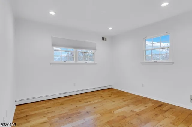 an empty room with a wooden floor and a window