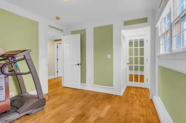 a view of a bedroom with wooden floor and furniture
