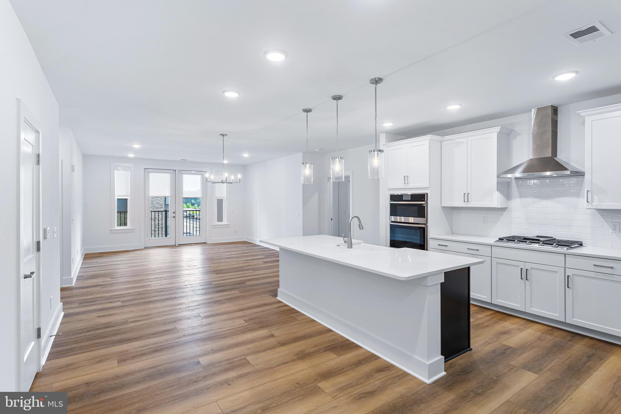 76 Old Mill Bottom Road North, Unit 310 Annapolis, MD 21409 - Photo 15 of 33 a large kitchen with stainless steel appliances kitchen island granite countertop a large stove a sink dishwasher and white cabinets with wooden floor