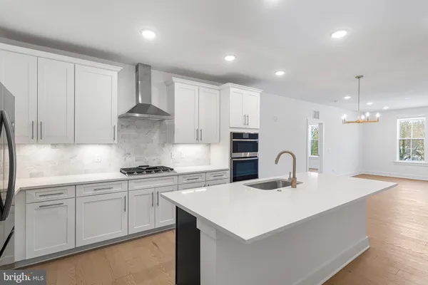 a kitchen with kitchen island a sink stainless steel appliances and cabinets