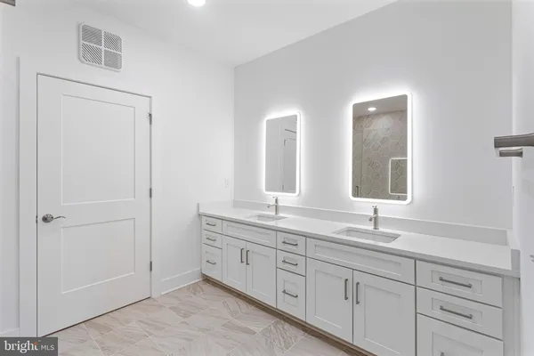 a bathroom with double sink and a mirror