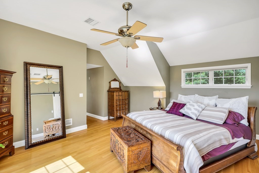 359 Service Road East Sandwich, MA 02537 - Photo 22 of 36 a bedroom with a bed and a chandelier