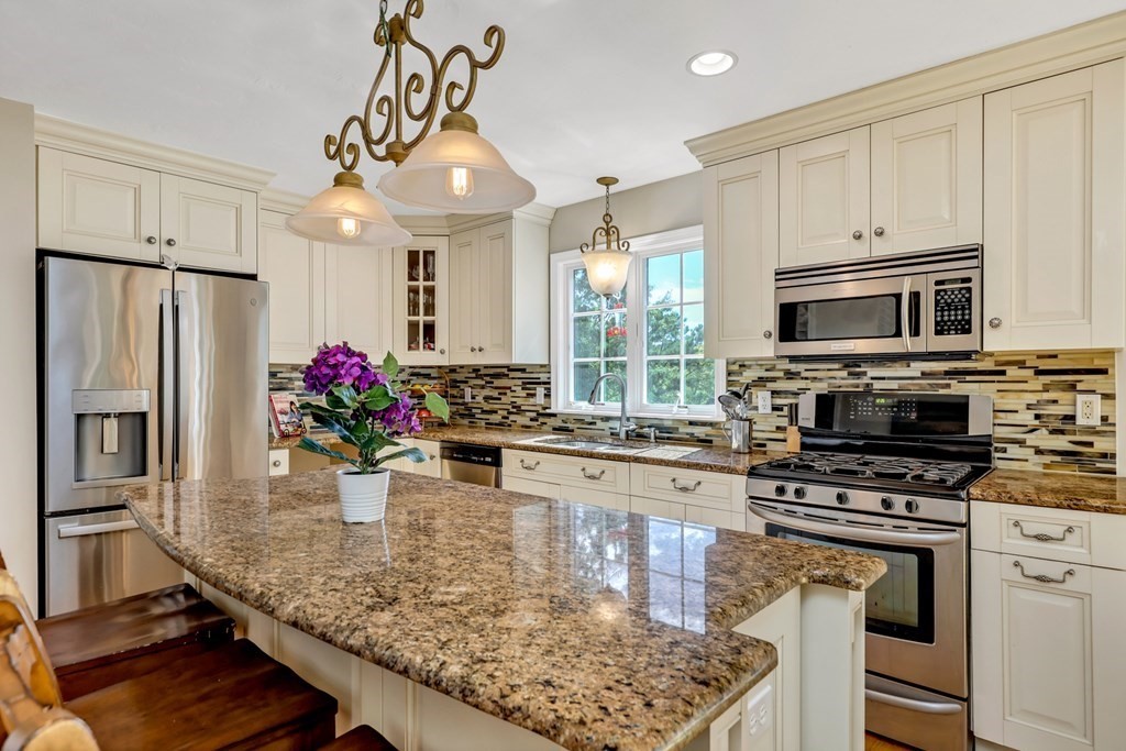 359 Service Road East Sandwich, MA 02537 - Photo 4 of 36 a kitchen with stainless steel appliances granite countertop a stove refrigerator sink and microwave