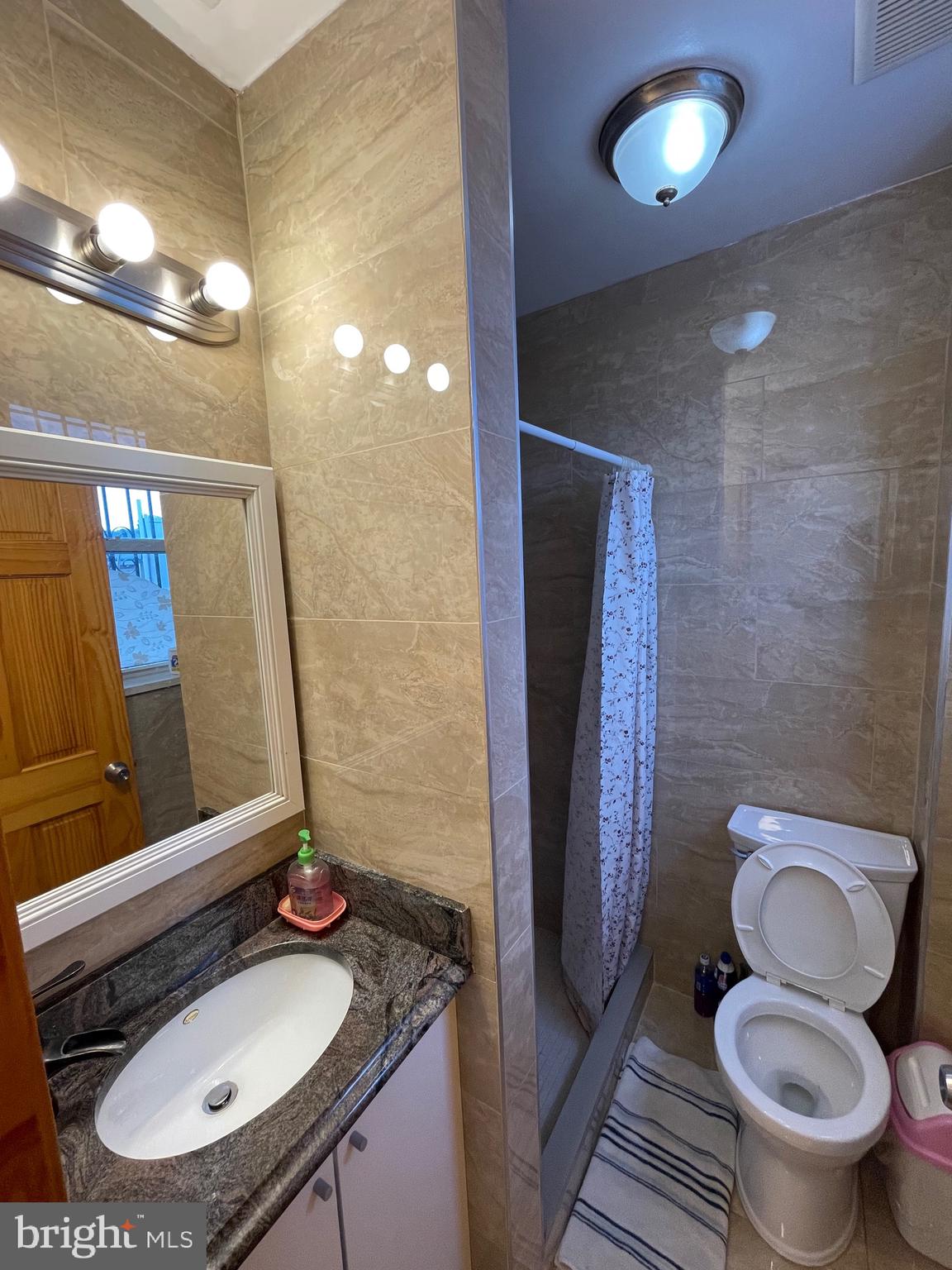 813 Federal Street Philadelphia, PA 19147 - Photo 14 of 28 a bathroom with a granite countertop toilet sink and mirror