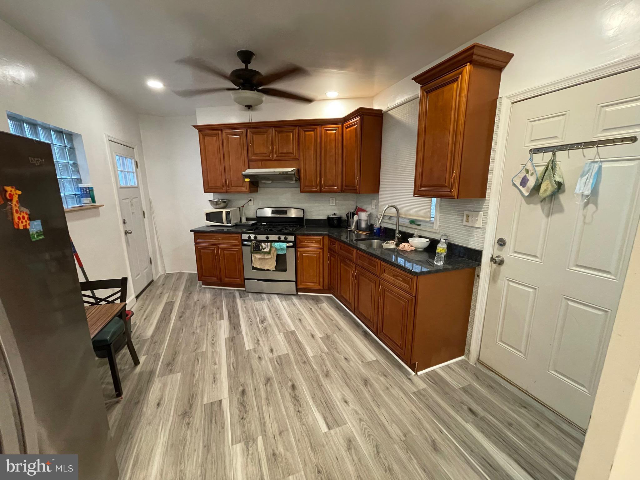 813 Federal Street Philadelphia, PA 19147 - Photo 3 of 28 a kitchen with stainless steel appliances a stove a sink a refrigerator wooden floor and cabinets