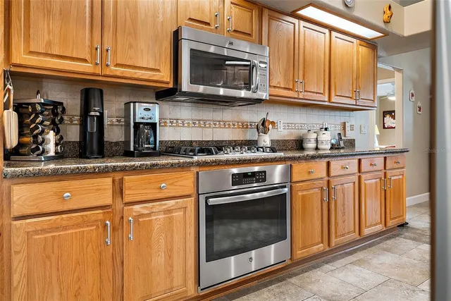 a kitchen with granite countertop cabinets stainless steel appliances and a sink