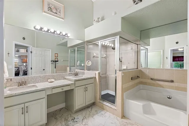 a bathroom with a tub a sink double vanity and a mirror