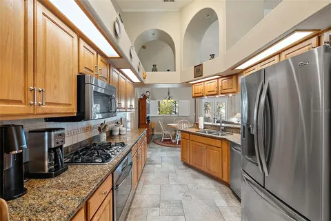 a kitchen with stainless steel appliances granite countertop a stove a sink dishwasher and a refrigerator