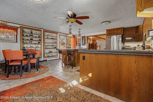 a living room with stainless steel appliances kitchen island granite countertop furniture and a large window
