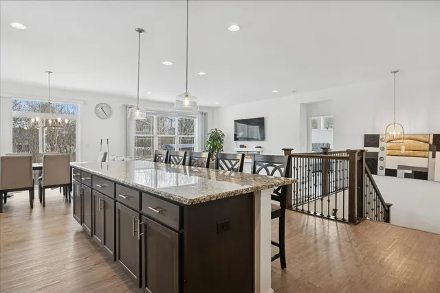 a kitchen with stainless steel appliances granite countertop a kitchen island a stove and a sink