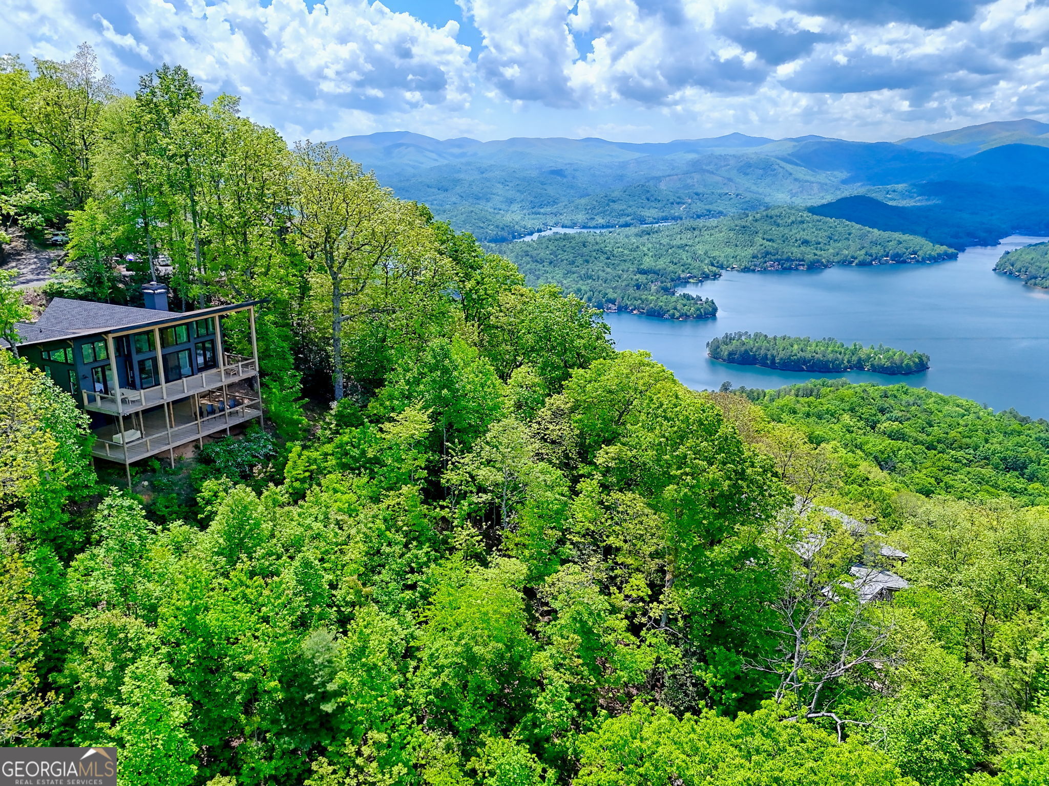 an aerial view of residential house with outdoor space and trees around