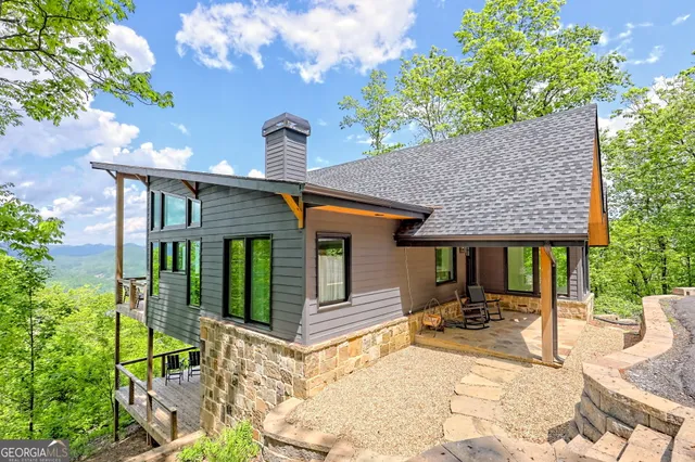 a living room with furniture a chandelier and a floor to ceiling window