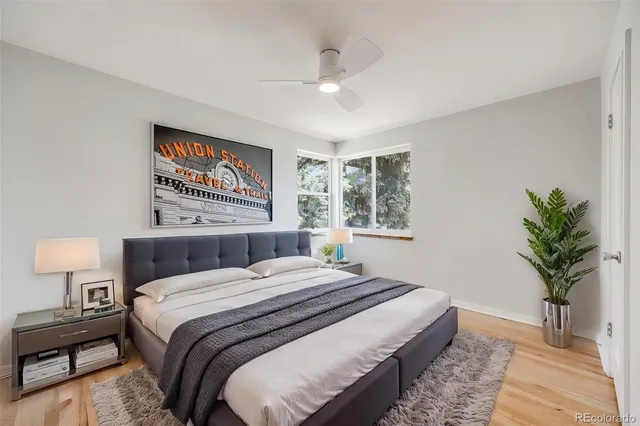 a bedroom with a large bed and a potted plant