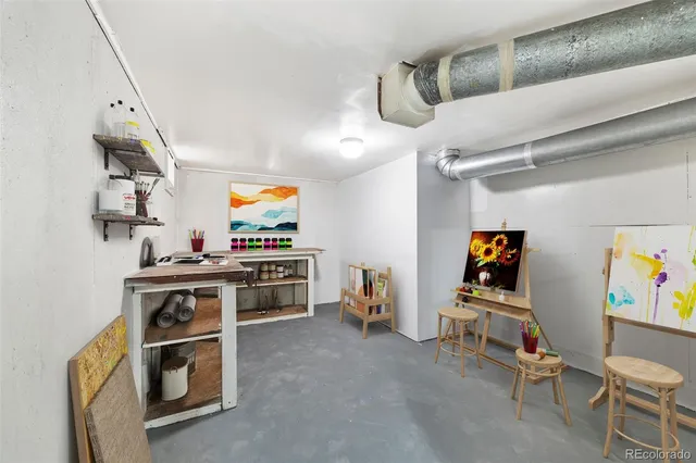 a view of a workspace with furniture and a window