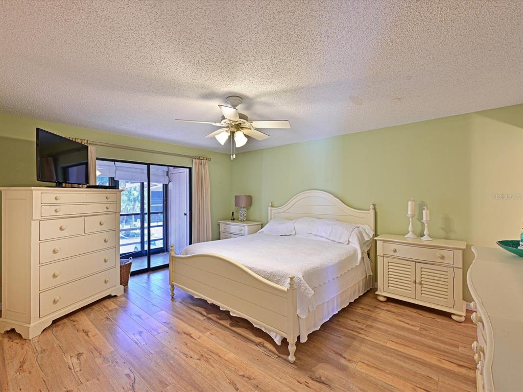 5400 34th Street West, Unit I9 Bradenton, FL 34210 - Photo 17 of 39 a bedroom with a bed and a chandelier