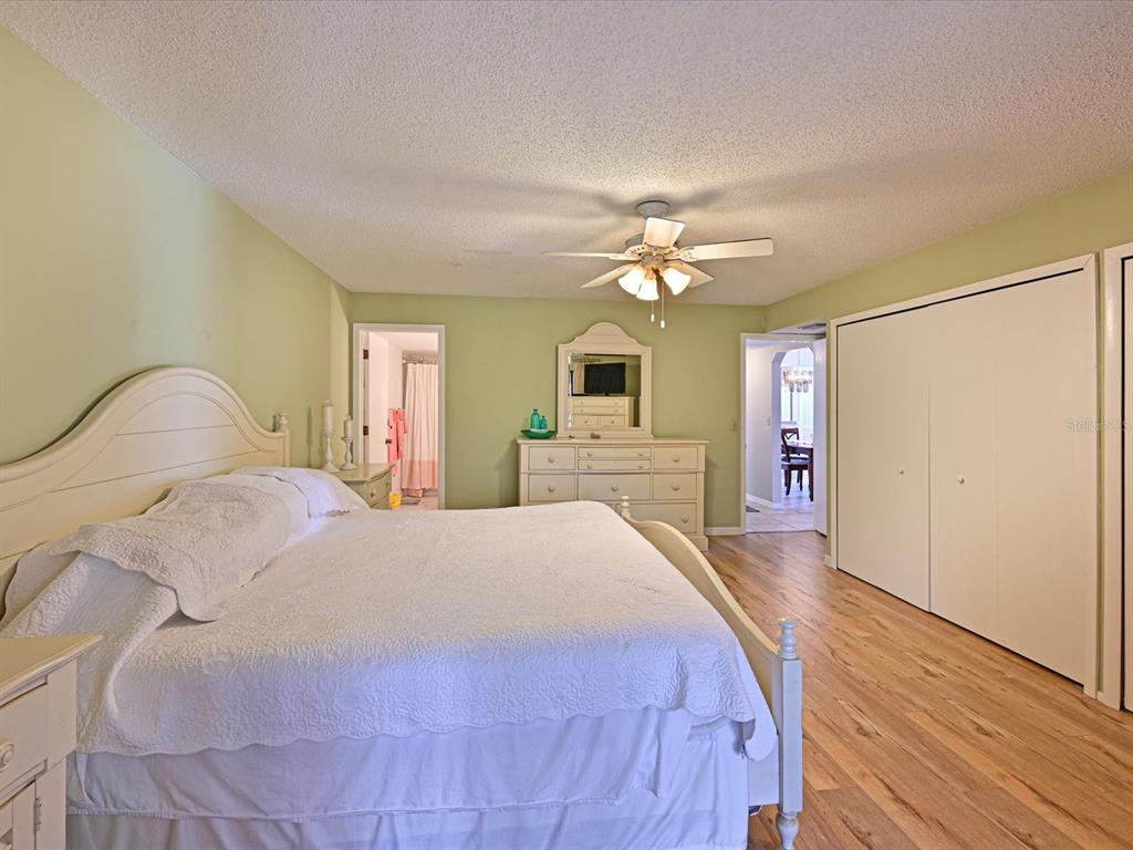 5400 34th Street West, Unit I9 Bradenton, FL 34210 - Photo 18 of 39 a bedroom with a bed and a chandelier
